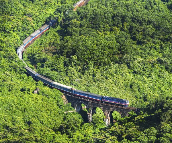 Reunification Express train moving through Bach Ma mountains near Hue